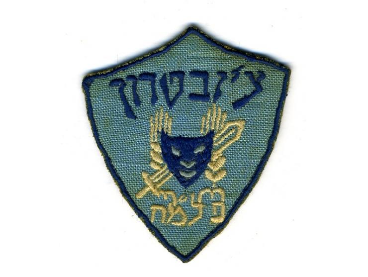 תג בד רקום, "צ'יזבטרון – פלמ"ח". [ארץ ישראל, סוף שנות ה-40].
 תג בצורת תגי-בד צבאיים, עם סמל הפלמ"ח (שתי 